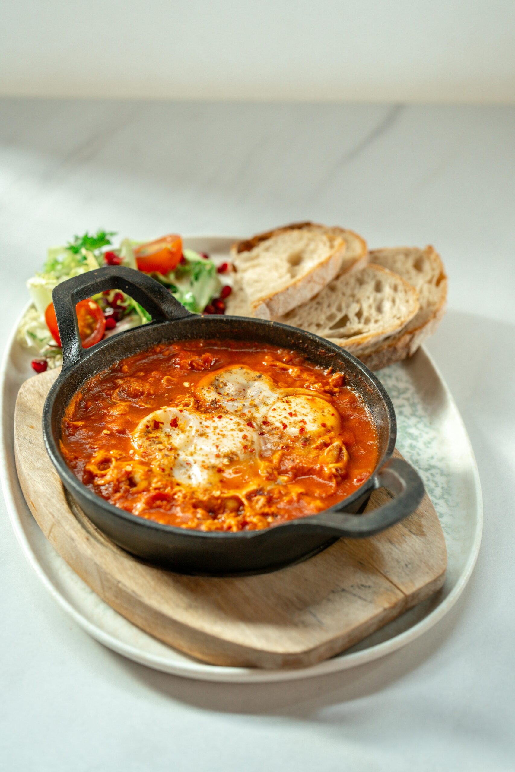Shakshuka serpenyőben, friss salátával és pirítóssal