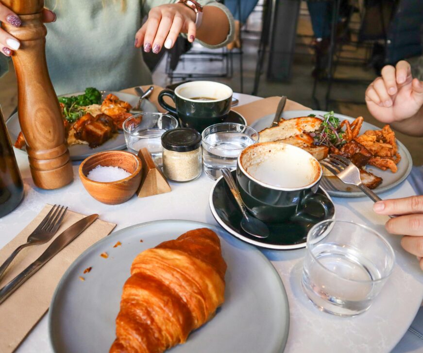 Barátok brunchoznak kávé és croissant mellett